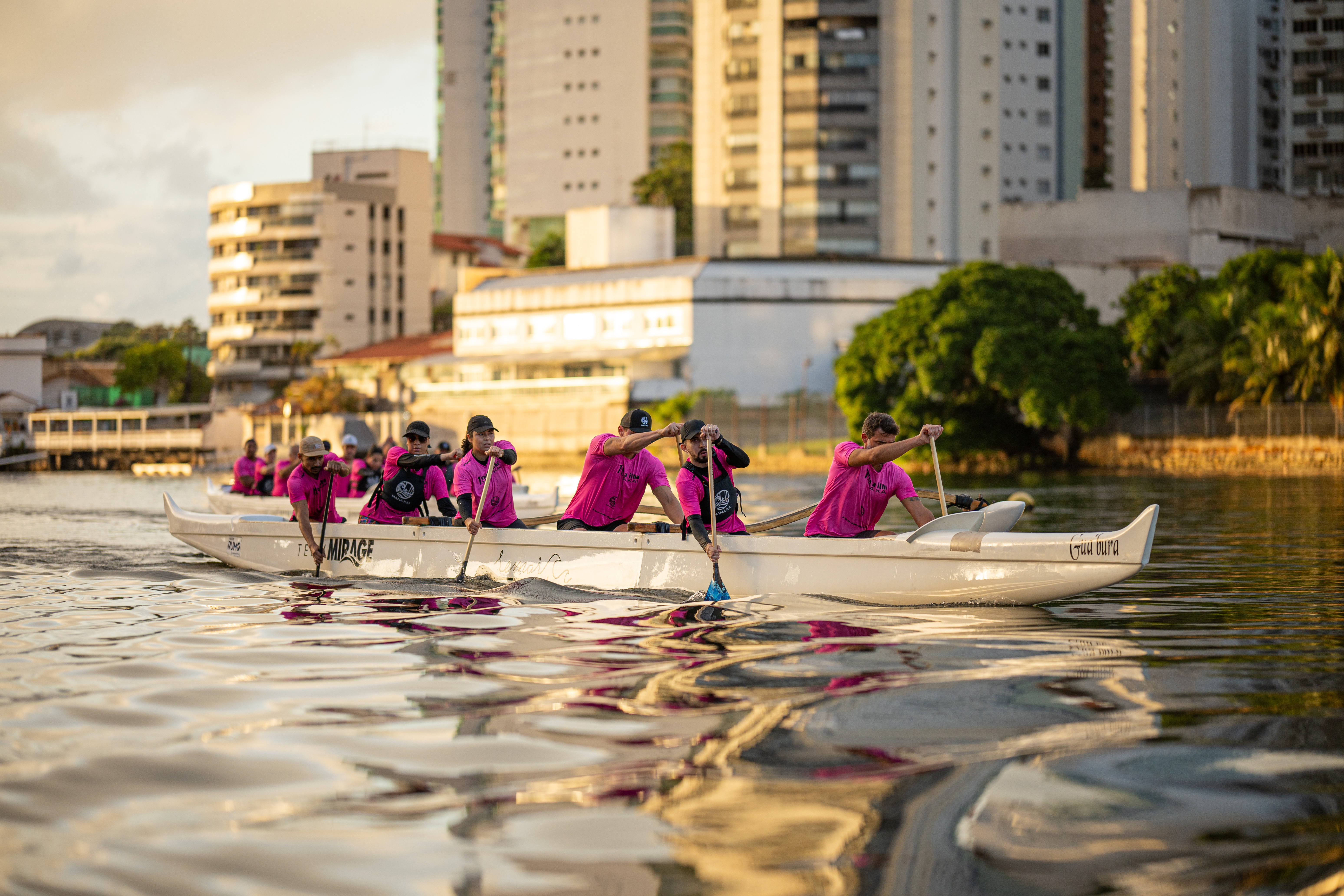 Equipe corporativa remando canoa havaiana